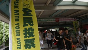 A banner urging people to vote is displayed outside a polling station during an unofficial referendum in Hong Kong on June 22, 2014. (REUTERS/Bobby Yip)