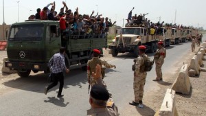 Iraqi men who volunteered to join the fight against a major offensive by jihadists in northern Iraq stand on army trucks as they leave a recruiting center in Baghdad on June 13, 2014. (AFP PHOTO/ALI AL-SAADI)
