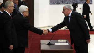 Palestinian Foreign Minister Riyad Al-Maliki (R) is sworn in along with the new Palestinian unity government in the presence of Palestinian president Mahmud Abbas (2nd-L) and Prime Minister Rami Hamdallah (L) in the West Bank city of Ramallah on June 2, 2014. (AFP PHOTO/ABBAS MOMANI)