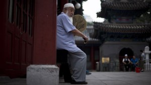 A Chinese Muslim man fans himself as he waits for the time to break his fast during the Muslim holy month of Ramadan at the Niujie mosque, the oldest and largest mosque in Beijing, on July 2, 2014. (AP Photo/Andy Wong)