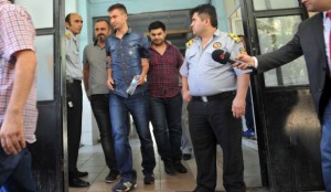 An unidenfied police officer (C) detained as part of a criminal probe over alleged corruption arrives at a hospital for a medical check-up at the start of his custody in Istanbul on July 22, 2014. (AFP PHOTO / OZAN KOSE)