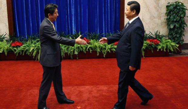 China’s Xi, Japan’s Abe hold landmark meeting after awkward handshake