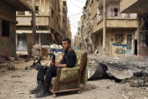 A member of the Free Syrian Army sits on a sofa in the middle of a debris-strewn street in Deir al-Zor, Syria, on April 2, 2013, Reuters