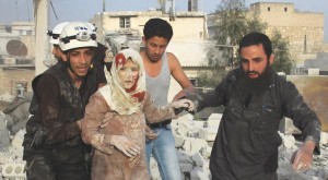Cicilians and paramedics rescuing an injured woman following an air raid waged by Assad's regime north Aleppo