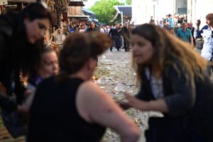 A woman gives first aid to a injured woman as broken pieces of glass are seen following a bombing, in Bursa, northwestern Turkey, on April 27, 2016./ AFP