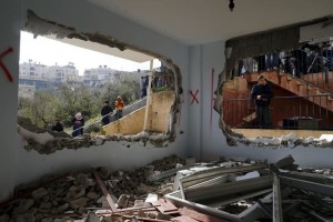 Relatives and onlookers look at the demolished house of Palestinian Allyan in Jabel Mukaber