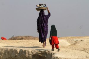 A woman carries laundry on her head, while heading home after washing in Charsadda, near Peshawar January 7, 2015. REUTERS/Fayaz Aziz