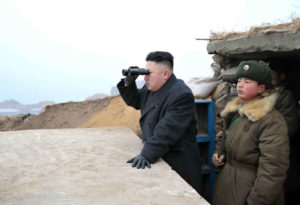 North Korean leader Kim Jong-Un uses a pair of binoculars to look towards the South
