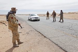 Libyan soldiers manning a military outpost, stop a car at a checkpoint in Wadi Bey, west of the city of Sirte, which is held by ISIS militants