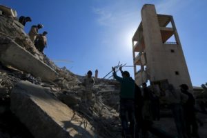 People and Civil Defense members remove rubble while looking for survivors in the ruins of a destroyed Medecins Sans Frontieres (MSF) supported hospital hit by missiles in Marat Numan, Idlib province, Syria