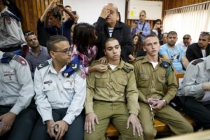 The father of an Israeli soldier who is charged with manslaughter, prays behind him in a military court during a remand hearing in Kiryat Malachi