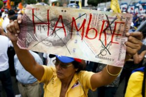 An opposition supporter with a giant 100-bolivar note with the word, Hungry, written on it seen at a gathering to protest against the government of Venezuelan President Nicolas Maduro.REUTERS