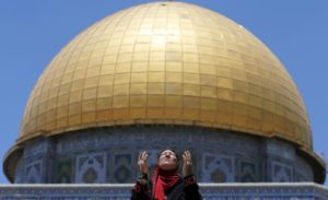 A Palestinian woman prays in front of the Dome of the Rock on the first Friday of the holy month of Ramadan at the compound known to Muslims as the Noble Sanctuary and to Jews as Temple Mount, in Jerusalem's Old City June 19, 2015. REUTERS/Ammar Awad