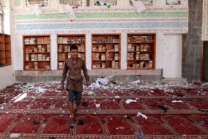 A Yemeni man inspects the damage following a bomb explosion at the Badr mosque in southern Sanaa on March 20, 2015.