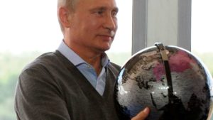 Russian President Vladimir Putin holds a terrestrial globe presented him as a gift in Tver region, Russia, on Friday. Mikhail Klimentyev.