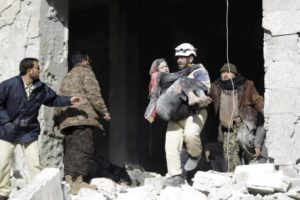 A civil defence member carries an injured woman in a site hit by what activists said were airstrikes carried out by the Russian air force in the rebel-controlled area of Maaret al-Numan town in Idlib province, Syria