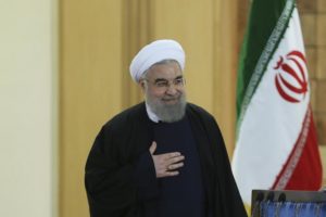 Iranian President Hassan Rouhani gestures as he arrives for a news conference in Tehran