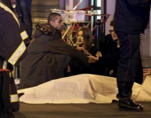Rescue services personnel work near covered bodies outside a restaurant following a shooting incident in Paris, France, November 13, 2015. REUTERS/Philippe Wojazer