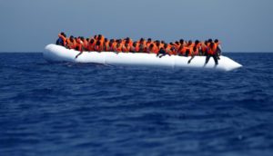 Migrants on a rubber dinghy wait to be rescued by the Migrant Offshore Aid Station (MOAS) ship MV Phoenix, some 20 miles (32 kilometers) off the coast of Libya, August 3, 2015. Some 118 migrants were rescued from a rubber dinghy off Libya on Monday morning. The Phoenix, manned by personnel from international non-governmental organizations Medecins san Frontiere (MSF) and MOAS, is the first privately funded vessel to operate in the Mediterranean. REUTERS/Darrin Zammit Lupi