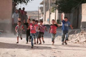 Children flash victory signs as they play in Manbij, in Aleppo Governorate.