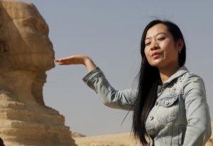 A Chinese tourist poses for a photo in front of the Sphinx at the Giza Pyramids on the outskirts of Cairo, Egypt March 2, 2016. REUTERS/Amr Abdallah Dalsh