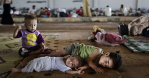 Syrian children lie on the ground while they and others take refuge at the Bab Al-Salameh border crossing, in hopes of entering one of the refugee camps in Turkey, near the Syrian town of Azaz, Aug. 26, 2012. AP