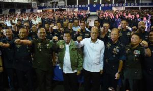 Philippine President Rodrigo Duterte (C) wearing an air force jacket given to him as a gift, poses for photos with Defense Secretary Delfin Lorenzana (4th R) and Military chief General Ricardo Visaya (3rd L) and air force personnel prior to the traditional meal dubbed "boodle fight" during the 250th Presidential Airlift Wing Command anniversary celebrations at Villamor air base in Manila on September 13, 2016.