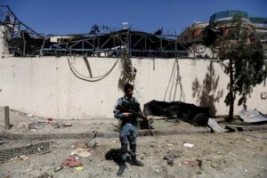 An Afghan policeman stands at the site of a car bomb attack in Kabul