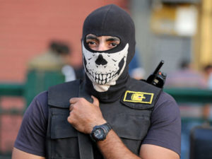 A masked member of security forces secures Tahrir Square in Cairo