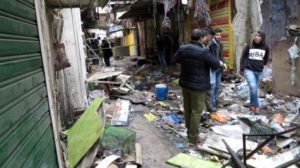 Iraqi security forces inspect the site of a bomb attack at a market in central Baghdad