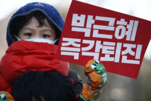 A South Korean child holds up a placard reading 'Park Geun Hye out' during a rally against the South Korean president on Dec 10, 2016.