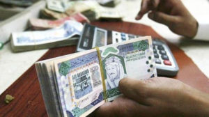 A Saudi money changer counting Saudi Riyals in Riyadh, Saudi Arabia.