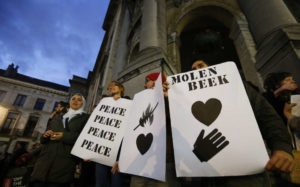 Residents of the Brussels suburb of Molenbeek take part in a memorial gathering to honour the victims of the recent deadly Paris attacks, in Brussels