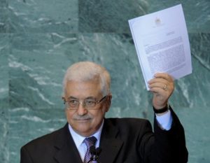 Mahmoud Abbas holds a copy of the letter requesting Palestinian statehood as he speaks during the United Nations General Assembly on 23 September, 2011 (AFP)