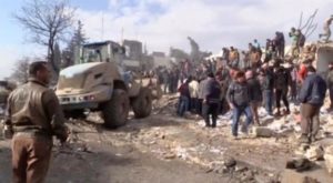 A still image taken from a video obtained by Reuters shows people and a bulldozer moving debris after a fuel truck exploded in the centre of rebel-held Azaz, Syria