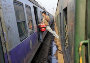 A vendor moves from one train to another at a railway station in Kolkata