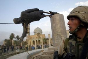 A U.S. soldier watches as a statue of Iraq's President Saddam Hussein falls in central Baghdad, April 9, 2003. REUTERS/Goran Tomasevic