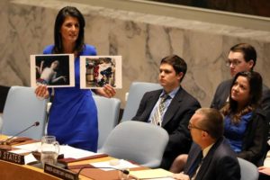 U.S. Ambassador to the United Nations Nikki Haley holds photographs of victims during a meeting at the United Nations Security Council on Syria at the United Nations Headquarters in New York City