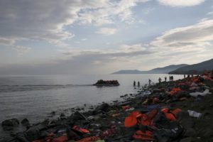 Refugees and migrants on an inflatable raft approach the shores of the Greek island of Lesbos