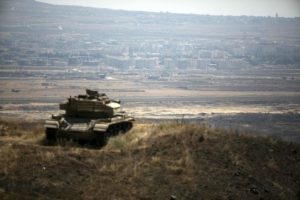 The Syrian area of Quneitra is seen in the background as an out-of-commission Israeli tank parks on a hill, near the ceasefire line between Israel and Syria, in the Israeli-occupied Golan Heights