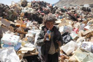A boy drinks expired juice on a pile of rubbish at landfill site on the outskirts of Sanaa, Yemen November 16, 2016. REUTERS/Mohamed al-Sayaghi
