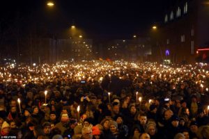 Hundreds of Danes hold candles and torches during a memorial service in Copenhagen for the two men who were killed in the double-attacks in the capital.