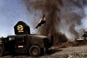 An explosion hits near a vehicle belonging to Iraq's elite Rapid Response Division on February 25, 2017, during the assault to retake the western half of Mosul, which is still occupied by ISIS group jihadists