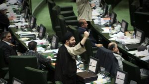 An Iranian Member of Parliament (MP) shakes his fist as he chants anti-Britain slogans during a debate in parliament