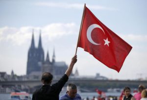 A supporter of Turkish President Erdogan waves a Turkish flag during a pro-government protest in Cologne