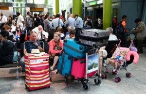 People wait with their luggage at Heathrow Terminal 5 in London