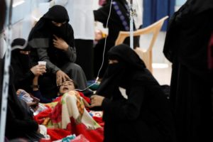 Women help a young relative infected with cholera at a hospital in Sanaa