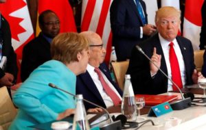 German Chancellor Angela Merkel sits next to Tunisia's President Beji Caid Essebsi and speaks to U.S. President Donald Trump as they attend a G7 expanded session during the G7 Summit in Taormina