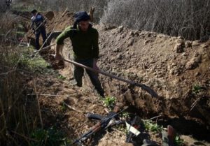 Fighters from the Free Syrian Army's Al Majd Brigades dig a trench in the rebel held besieged area of al-Marj in the Eastern Ghouta of Damascus