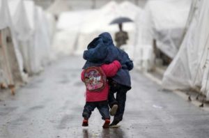 Syrian boys walk shoulder to shoulder in the rain at the Boynuyogun refugee camp on the Turkish-Syrian border in Hatay province.